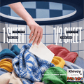 Hand dropping a Klevay detergent sheet onto a pile of colourful laundry, one sheet per load