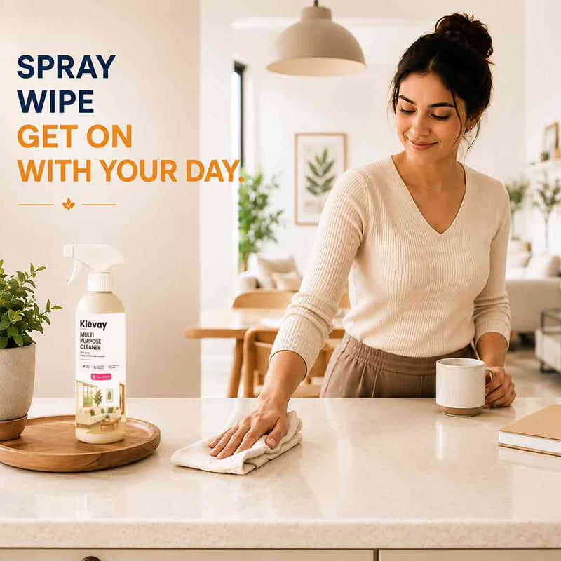 Woman wiping a kitchen counter after using Klevay multi-purpose cleaner: spray, wipe, get on with your day