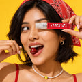 Smiling woman in a red bandana holding a Klevay Instant Stain Remover Spray bottle